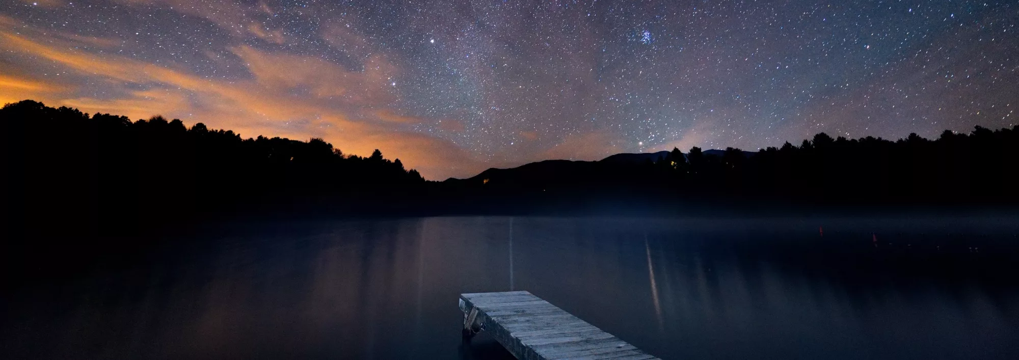A lake, sunset, a smattering of stars - symbolizing the hope and direction you have with a good financial manager like Velorum Wealth Management.
